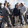 Migranti sbarcano nel porto di Lampedusa. Marzo 27, 2011 (ANSA/FILIPPO VENEZIA) 