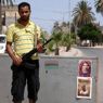 Un posto di blocco con la foto di Gheddafi e lo slogan "vivo o morto" 