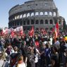 Il corteo dei manifestanti passa davanti al Colosseo (Ansa) 