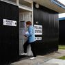 Nella foto una donna arriva entra in un seggio elettorale in uno chalet a Dymchurch, nel sud dell'Inghilterra (Reuters) 