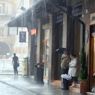 Persone si riparano dalla piogga a Bologna dove il maltempo ha portato abbondandti precipitazioni (Ansa) (ANSA)