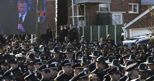 Gli agenti di polizia newyorchesi voltano le spalle al megaschermo durante il discorso del sindaco de Blasio (Reuters) (REUTERS)