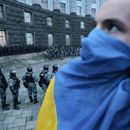 Nella foto un dimostrante con la bandiera dell'Ucraina sulla bocca durante le manifestazioni e gli scontri di domenica contro la Polizia (Space24)