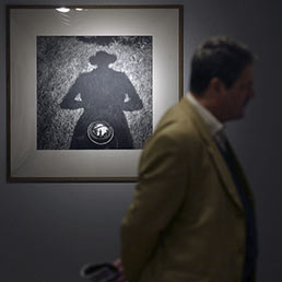 Un visitatore cammina accanto a una delle fotografie di Vivian Maier esposta alla mostra "Street Photographer" (Corbis)