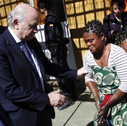 Il ministro Jorge Fernandez Diaz con una donna immigrata in un centro per rifugiati in Spagna (Reuters)