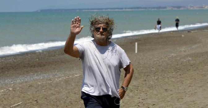 Una corona di "spine", realizzata con alghe raccolte sulla spiaggia, per assumersi la colpa del mancato successo elettorale. Beppe Grillo si è fatto fotografare così a Marina di Bibbona, dove è in vacanza (Ansa)