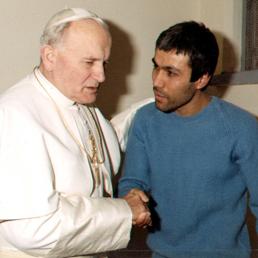 Papa Giovanni Paolo II mentre parla con il suo attentatore Mehmet Alì Agca (Ansa)