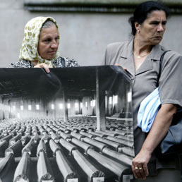 Alcune madri mostrano la foto di circa 600 bare del massacro di Srebrenica (Afp)