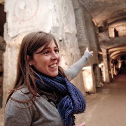 Nella foto una guida della cooperativa La Paranza di Napoli durante una visita alle Catacombe di San Gennaro