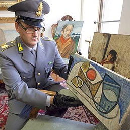 Un finanziere mostra una delle opere sequestrate a Calisto Tanzi