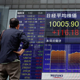 Un schermo all'esterno della Borsa di Tokyo mostra l'indice Nikkei sopra i 10.000 punti, 20 luglio (AP)