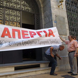 Striscione di protesta con la scritta "sciopero" davanti alla Banca Commerciale della Grecia ad Atene. Lug 8, 2011 (Epa)