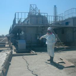 Un operatore della centrale mostra una crepa vicino al reattore 2 della centrale di Fukushima. Apr 2, 2011 (Reuters)