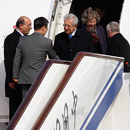 Monti: all'estero attesa per la riforma. Nella foto il presidente del Consiglio, Mario Monti, al suo arrivo all'aeroporto di Beijing insieme alla moglie Elsa (AP Photo)