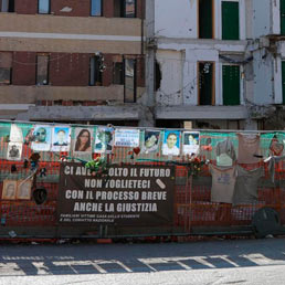 L'area dove sorgeva la Casa dello studente all'Aquila, con le foto degli otto ragazzi che morirono nel crollo del palazzo. (Ansa)