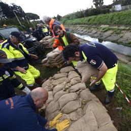 Alcuni uomini della protezione civile mettono in sicurezza il Canale Palocco con sacchi di sabbia, Roma - Ansa