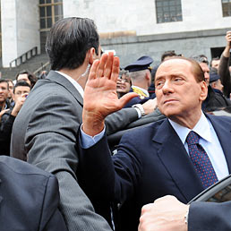 Nella foto l'ex premier, Silvio Berlusconi, circondato dalla sua scorta davanti all'ingresso del Palazzo di giustizia di Milano in un'immagine d'archivio (Ansa)