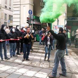 Torino, giovani dei centri sociali sfilano con la maschera di anonymous e fumogeni durante il corteo del Primo Maggio (Ansa) 