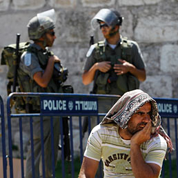 Nella foto un musulmano si siede accanto a un posto di blocco della polizia israeliana vicino alla Porta di Damasco nella città vecchia di Gerusalemme durante il terzo Venerdì del mese sacro del Ramadan (Reuters)