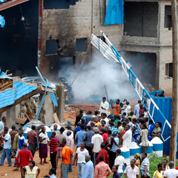 La folla raccolta davanti alla chiesa cristiana di Jos crollata, in Nigeria, dopo un attacco terroristico (Ap)