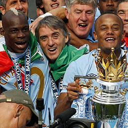 Il capitano del Manchester City, Vincent Kompany (a destra) con il trofeo della Premier League, festeggia insieme al tecnico Roberto Mancini (al centro) e a Mario Balotelli (AP Photo)