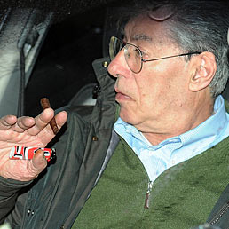 Umberto Bossi lascia a bordo della sua auto la sede della Lega in via Bellerio a Milano (Ansa)